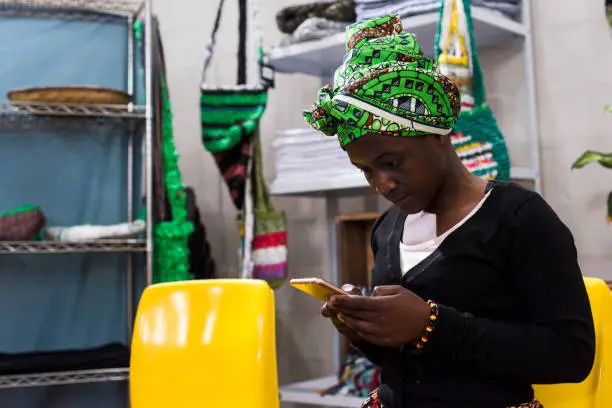 Photo of an African business woman using an iphone at work