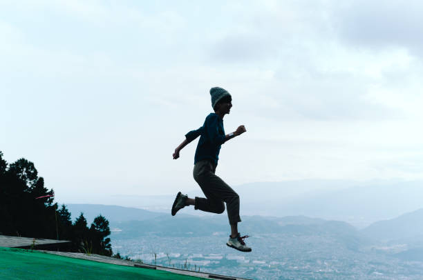istock Woman in mid-air jump above mountain ledge 865620564