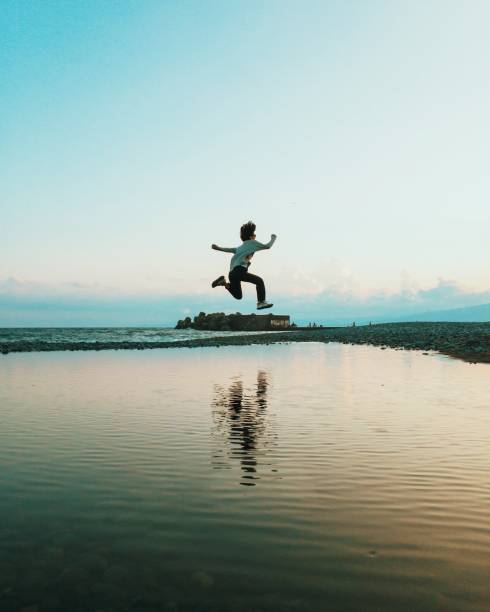 istock Woman in mid-air jump above water Reflected in Big Puddle 865622768
