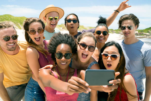 istock Friends taking selfie using mobile phone at beach 865625240