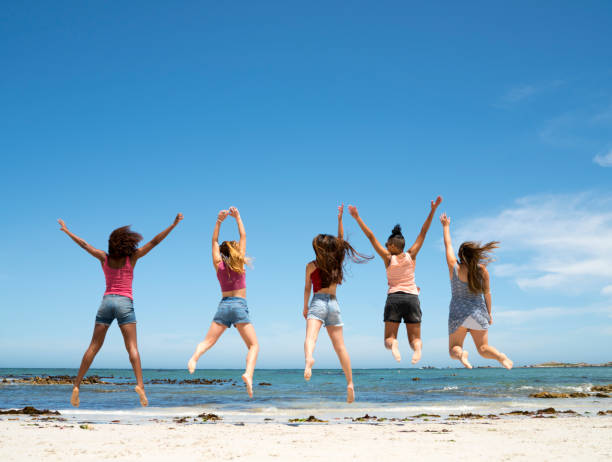 istock Female friends jumping at the beach 865627920