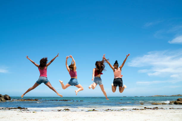 Rear back view photo of positive funny carefree group jump raise arms wear casual outfit nature summer seaside beach