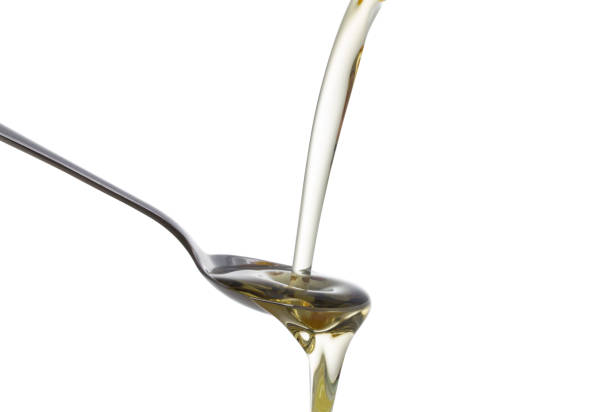 istock Olive oil poured from a bottle into a spoon. 865628446