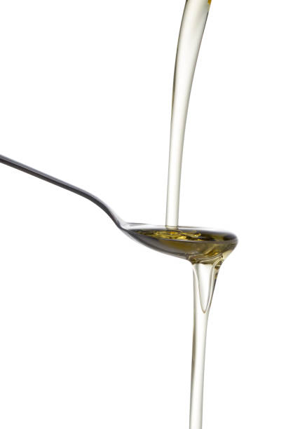 istock Olive oil poured from a bottle into a spoon. 865628568