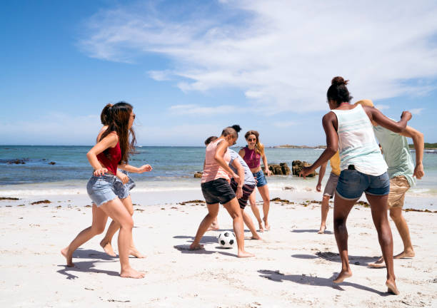 istock Multi-ethnic friends playing soccer at beach 865629088