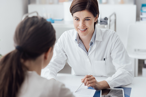 Female doctor giving a consultation to a patient and explaining medical informations and diagnosis