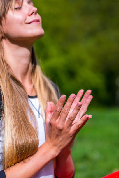 Joyful young woman doing yoga, focus on hands