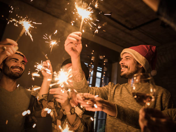 istock Group of young happy people having fun while using sparklers on New Year's party. 865635420