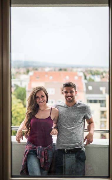 istock Young happy couple enjoying a day on a balcony. 865640922