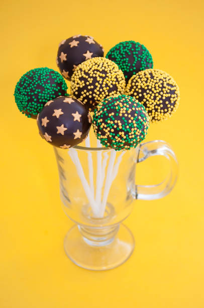 chocolate cake pops on a yellow background - flavored ice variation birthday candy imagens e fotografias de stock