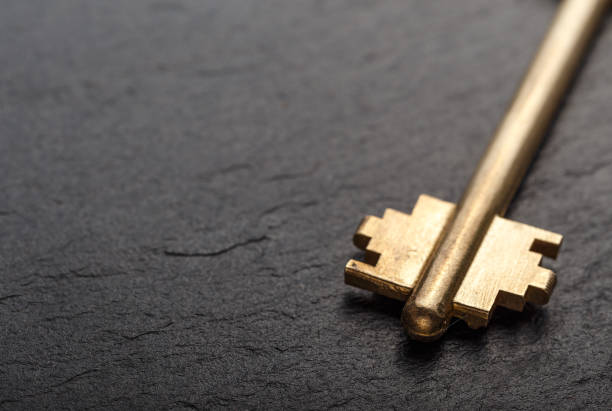 istock Golden metal key on a black background 865645080