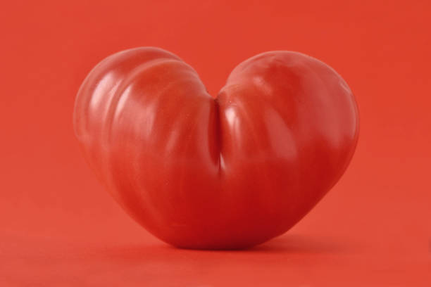 istock Heart shaped tomato on red background - Love concept 865647958
