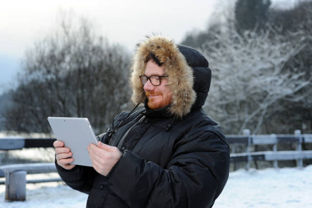 istock man with tablet in winter park 865648194