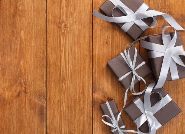 istock Presents in gift boxes on wood background with copy space 865648260