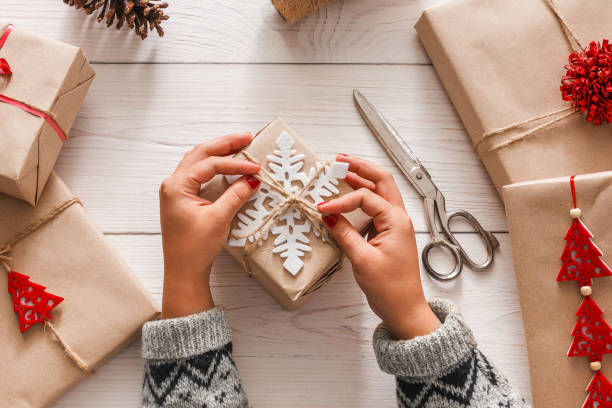 istock Woman's hands wrapping christmas holiday present with craft twine 865651626