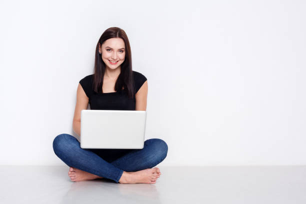 istock Woman using laptop sitting on the studio floor 865655690