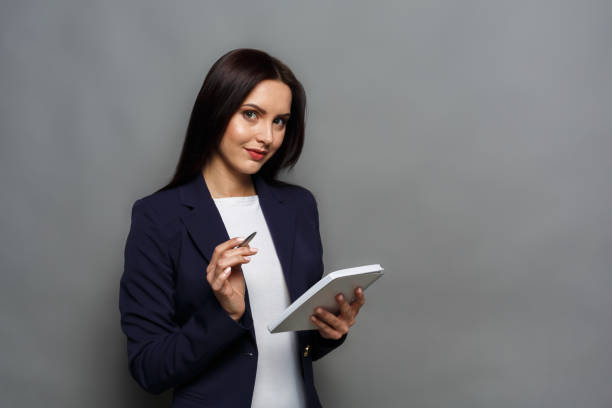 istock Woman with tablet on gray background 865656074