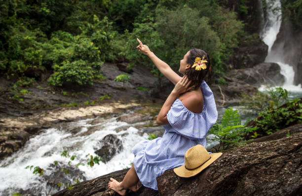 istock girl looks at the waterfall 865660308