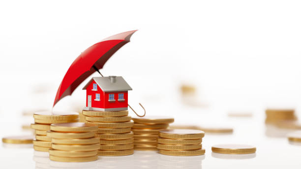 Red Toy House Sitting On White Background Behind Coin Stack: Insurance And Real Estate Concept Red toy house is sitting behind  a coin stack under a red umbrella. Horizontal composition with selective focus and copy space. Real Estate and Insurance Concept. recession protection stock pictures, royalty-free photos & images