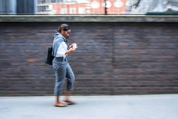 istock Businesswoman using mobile phone and holding coffee cup. 865667560