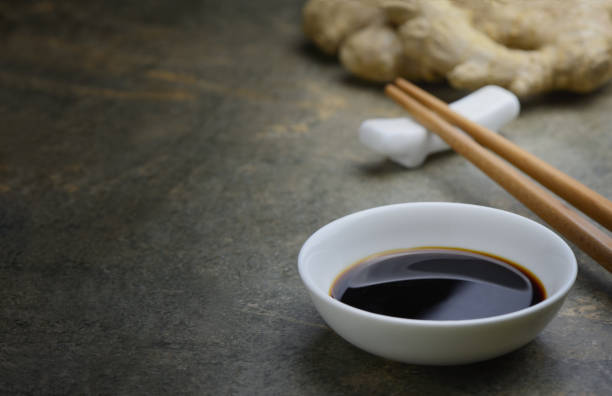 Soya sauce background Soya sauce in a white bowl on a kitchen dark stone table top, front view background with a space for a text soy sauce photos stock pictures, royalty-free photos & images