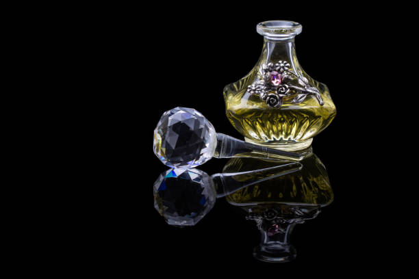 gros plan coup de luxe traditionnel arabe oud huile parfum dans une belle bouteille pot en verre cristal clair à la main et compte-gouttes en verre isolé sur fond noir style antique, espace de texte - shot glass glass black empty photos et images de collection