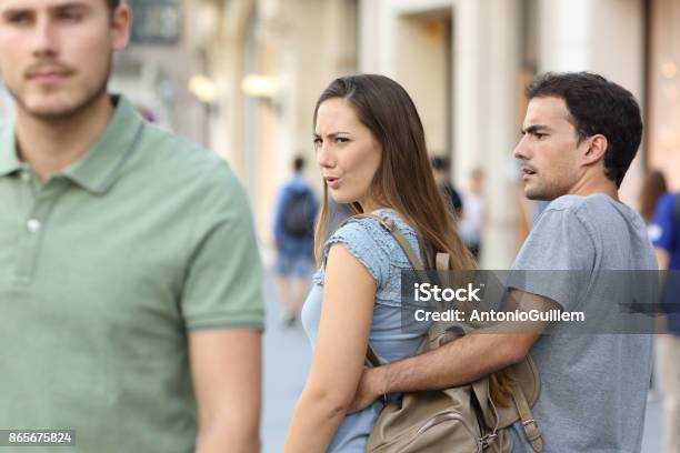 Disloyal Woman Looking Another Man And Her Angry Boyfriend Stock Photo - Download Image Now