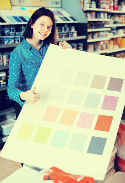 istock happy female customer examining color scheme variants in paint store 865680386