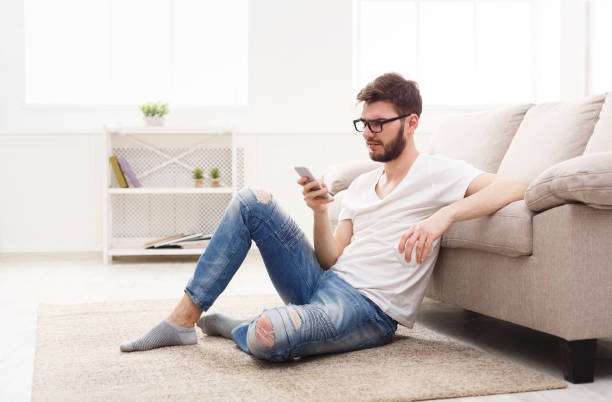istock Serious young man at home with mobile 865680666