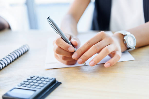 istock businesswoman holding pen 865680826