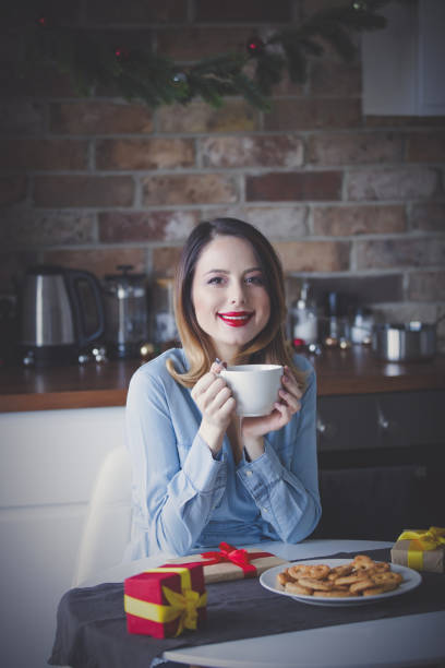 istock Beautiful young woman sitting and at kitchen 865684130
