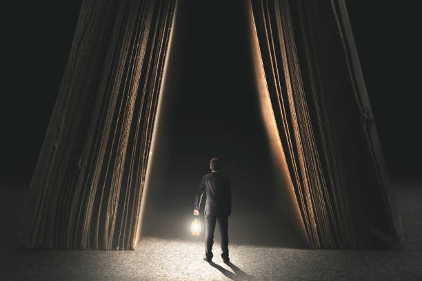 istock couriose man with lamp going to be wise in a book 865684358