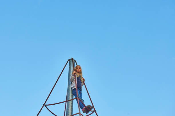 istock Active young child girl climbing the spider web playground activity. 865687766