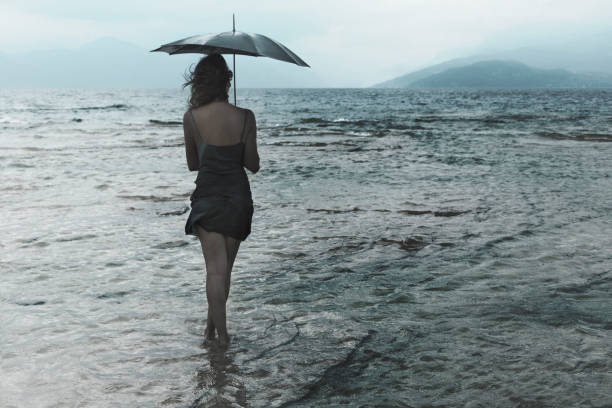 istock lonely woman meditating looking at infinity in the rain and thunderstorm 865691686