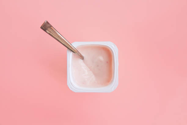 istock Strawberry pink yogurt with spoon in it. Flat lay. 865692636