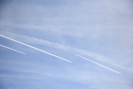 Jet airplane in sky, air routes by white vapor in flight - contrail, jet trail - condensation trail. Contrail-induced cloud (Cirrus tractus) in troposphere