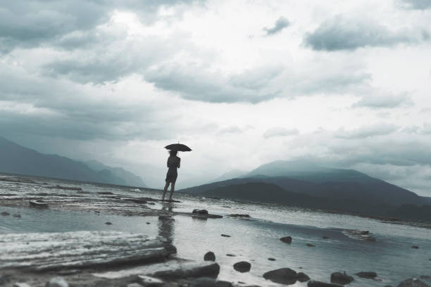 istock lonely woman meditating looking at infinity in the rain and thunderstorm 865696292