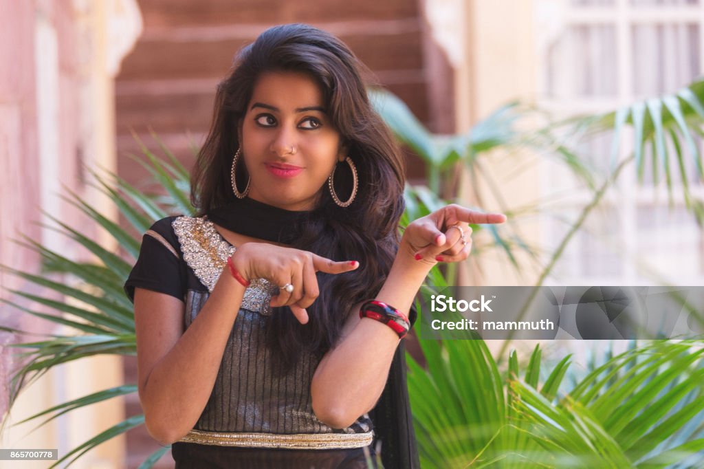 Young Indian Woman Making A Funny Pointing Gesture Stock Photo - Download  Image Now - iStock