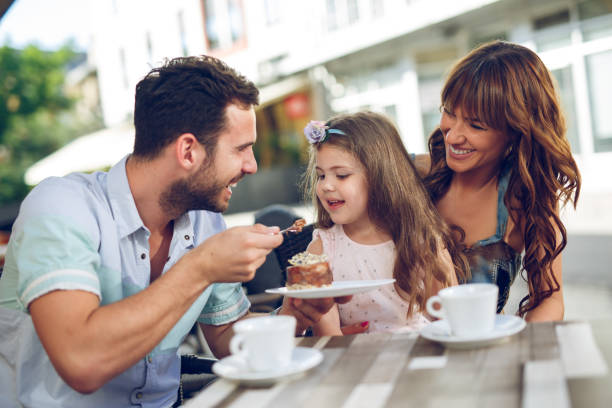 istock Young loving family having fun in a cafe eating cake. 865710112