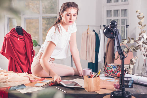 istock Fashion designers working in studio sitting on the desk 865712848