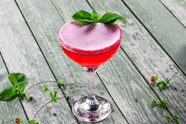 Glass of alcoholic raspberry and mint cocktail