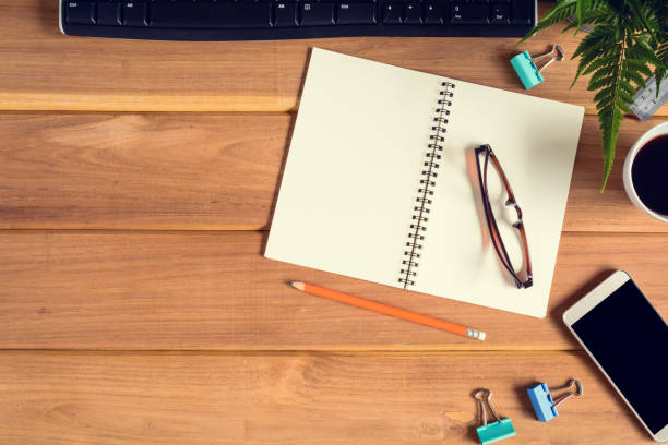 istock top view desk wood and office equipment 865714504