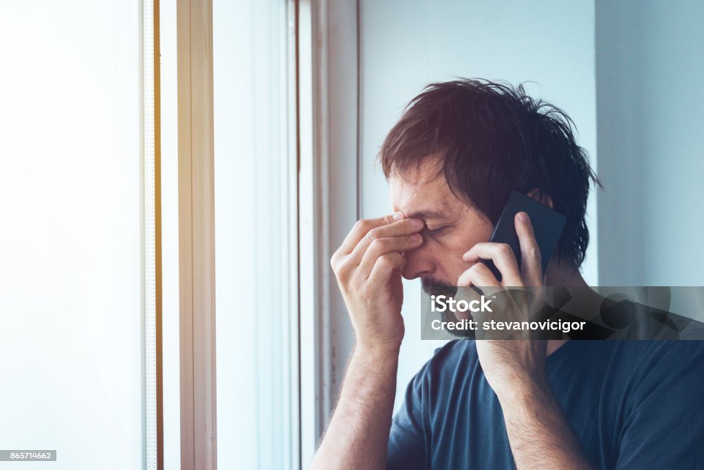 Unpleasant phone call Unpleasant phone call, worried anxious man talking with someone on mobile phone Using Phone Stock Photo