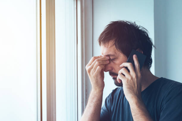 Unpleasant phone call Unpleasant phone call, worried anxious man talking with someone on mobile phone nettle stock pictures, royalty-free photos & images