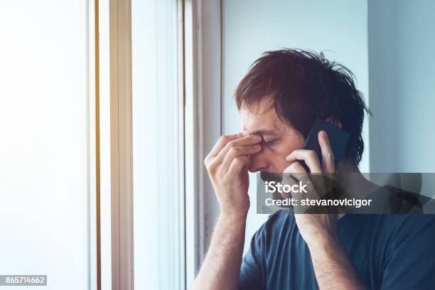 Unpleasant Phone Call Stock Photo - Download Image Now - Using Phone, Men, Displeased