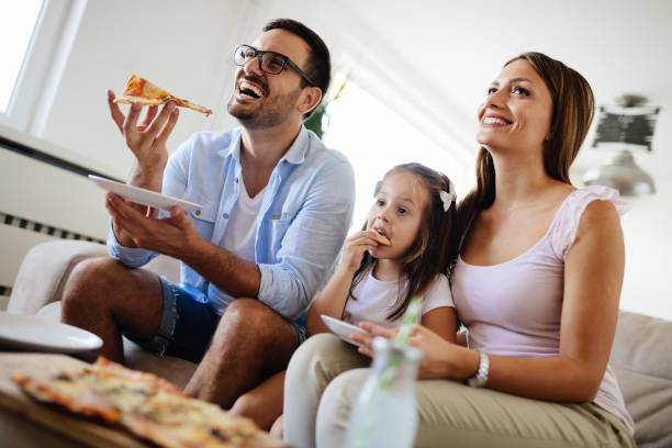istock Happy family sharing pizza together at home 865717090