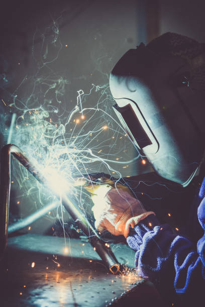 istock Welding steel pipe and producing sparks and colored smoke. 865718336