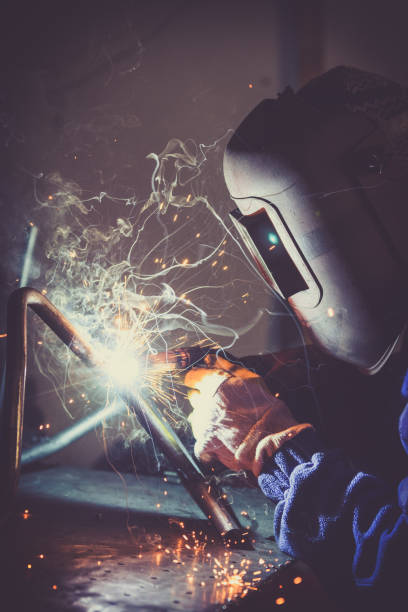 istock Welding steel pipe and producing sparks and colored smoke. 865718360