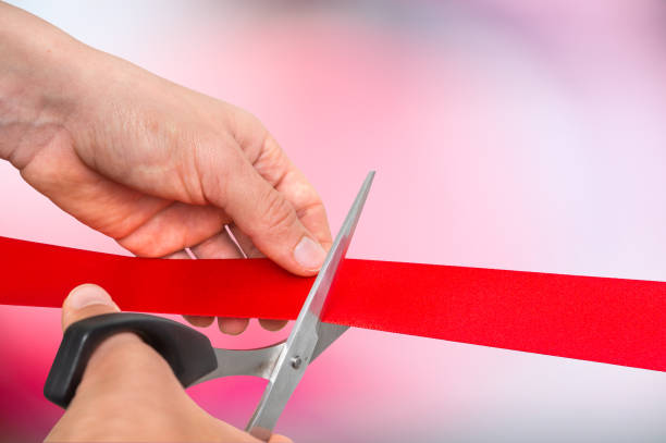 istock Hand with scissors cutting red ribbon - opening ceremony 865729466