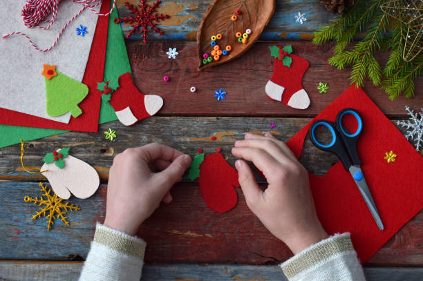 robienie ręcznie robionych świątecznych zabawek z filcu własnymi rękami. koncepcja diy dla dzieci. dokonywanie dekoracji drzewa xmas lub kartki z życzeniami. krok 3. udekoruj ekkoruj niasz - christmas child gift holiday zdjęcia i obrazy z banku zdjęć